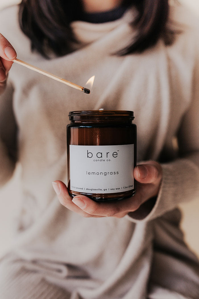 Lighting a Lemongrass soy candle with a match